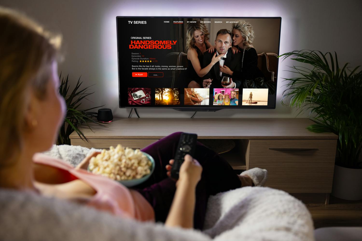 Netflix Nainen istuu sohvalla katsomassa Netflixiä.